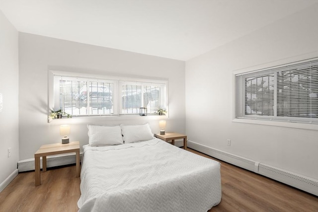 bedroom featuring baseboard heating and hardwood / wood-style floors