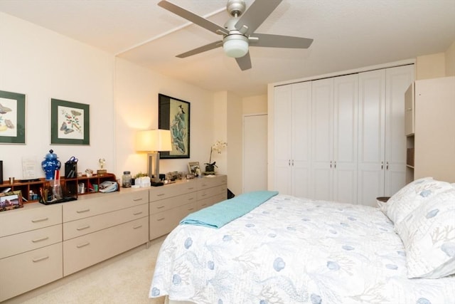bedroom featuring a closet, light carpet, and a ceiling fan