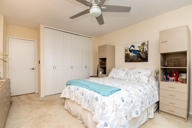 bedroom with light colored carpet, a closet, and a ceiling fan