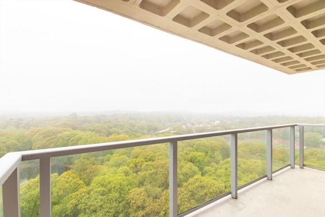 balcony featuring a wooded view
