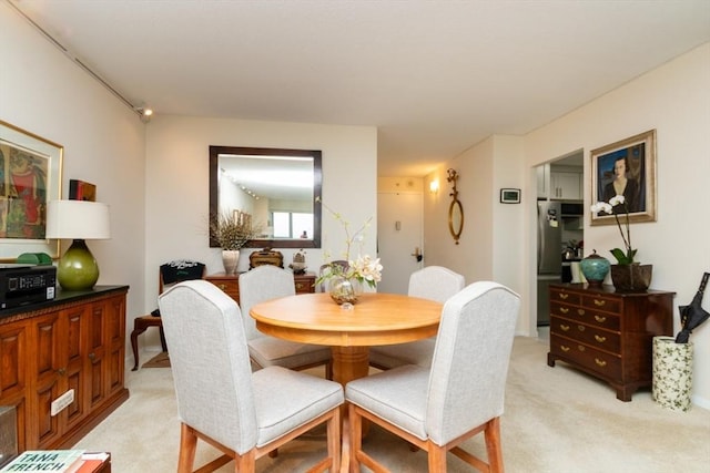 dining area featuring light carpet