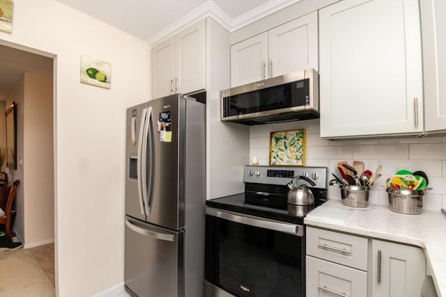 kitchen featuring appliances with stainless steel finishes, decorative backsplash, baseboards, and white cabinets