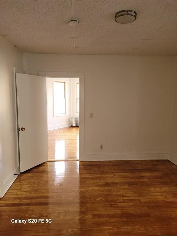 empty room with wood-type flooring and radiator