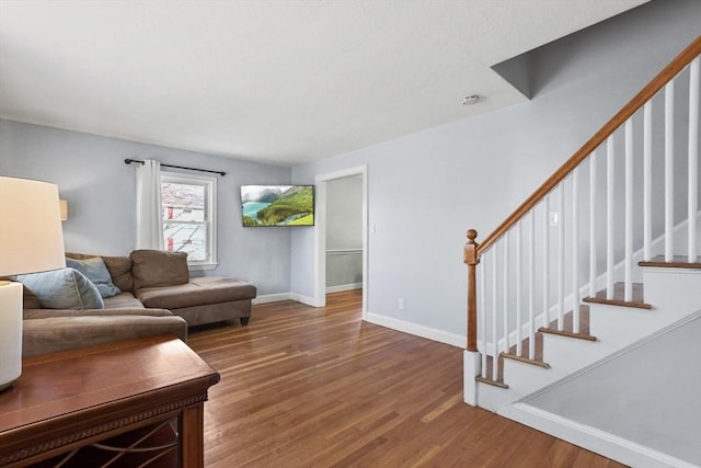 living room with stairway, wood finished floors, and baseboards