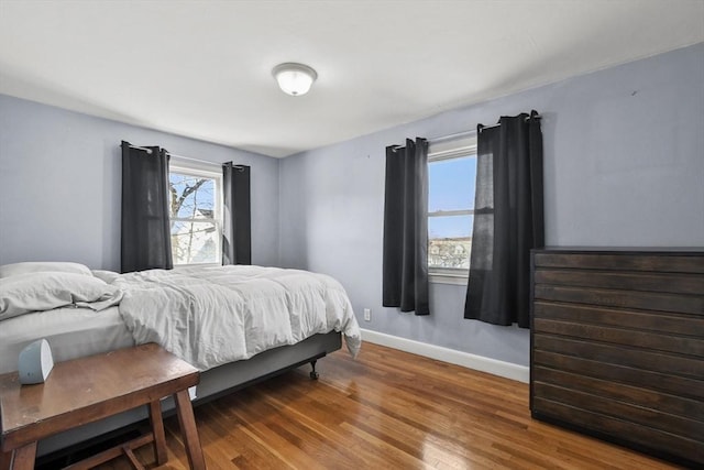 bedroom with wood finished floors and baseboards