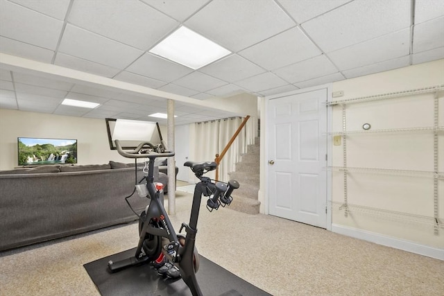 exercise room with a paneled ceiling and carpet flooring