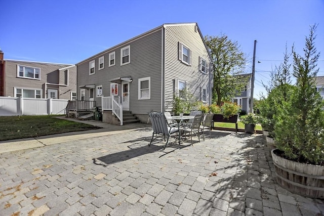 rear view of house featuring a patio and fence