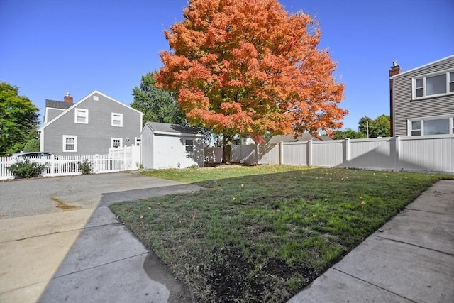 view of yard featuring an outbuilding, a storage unit, and a fenced backyard