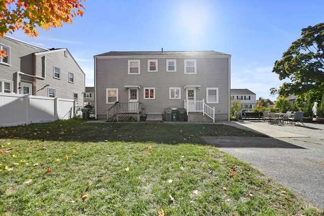 back of property featuring a yard, a patio, and fence