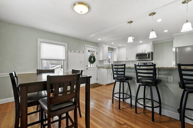 dining space with light wood-style floors, recessed lighting, and baseboards