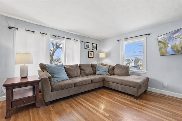 living area with light wood-type flooring and baseboards