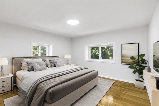 bedroom featuring wood finished floors and baseboards