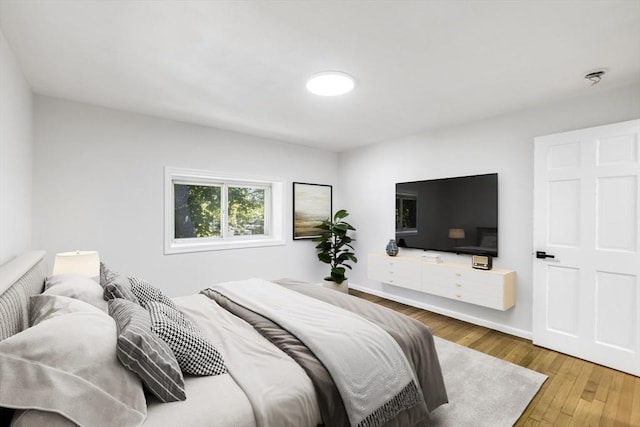bedroom with hardwood / wood-style floors and baseboards