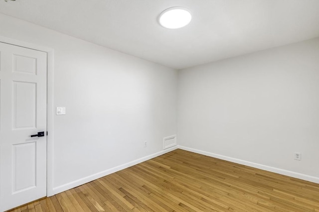 unfurnished room featuring baseboards and light wood-style floors