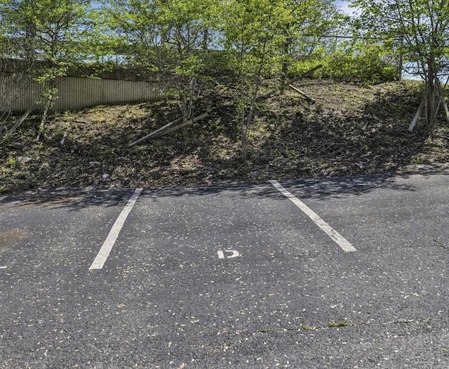 uncovered parking lot featuring fence