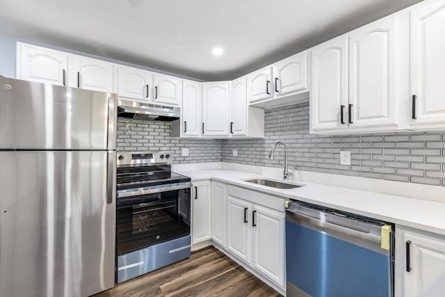 kitchen with stainless steel appliances, a sink, under cabinet range hood, white cabinetry, and light countertops