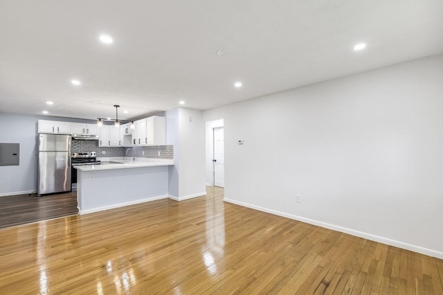kitchen featuring stainless steel appliances, open floor plan, recessed lighting, white cabinets, and a peninsula