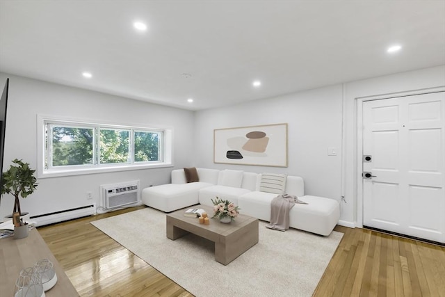 living area featuring a wall mounted air conditioner, recessed lighting, baseboard heating, and light wood-type flooring