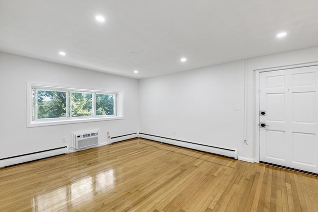 unfurnished room featuring baseboard heating, a wall unit AC, light wood-type flooring, recessed lighting, and a baseboard heating unit