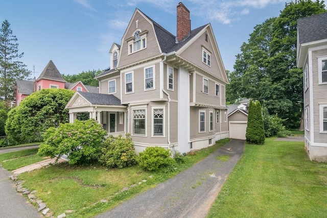 36 Butler Pl, Northampton, MA 01060 - view of front facade featuring a garage, a chimney, a front yard, and an outdoor structure