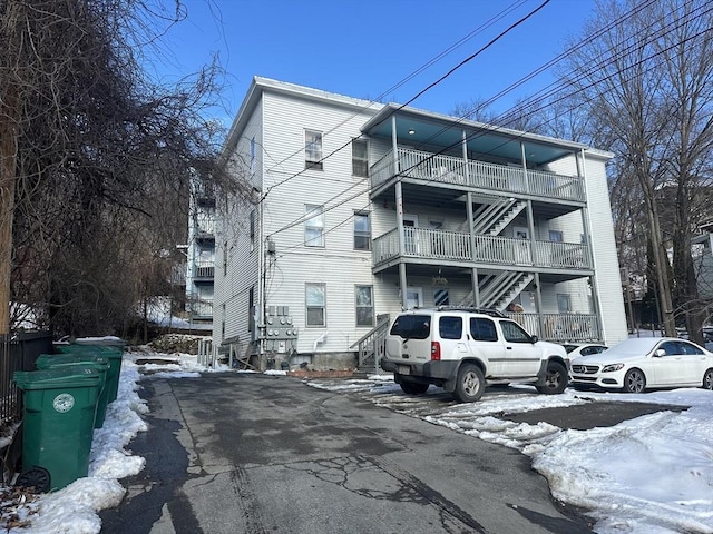 snow covered property featuring stairs