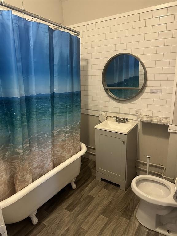 full bath featuring shower / bath combination with curtain, vanity, toilet, and wood finished floors