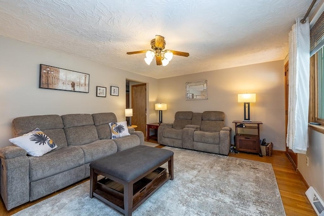 living room with wood-type flooring and ceiling fan