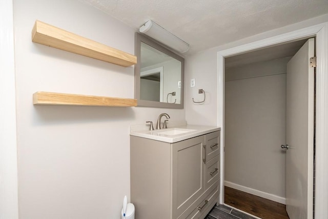 bathroom with vanity, hardwood / wood-style floors, and a textured ceiling