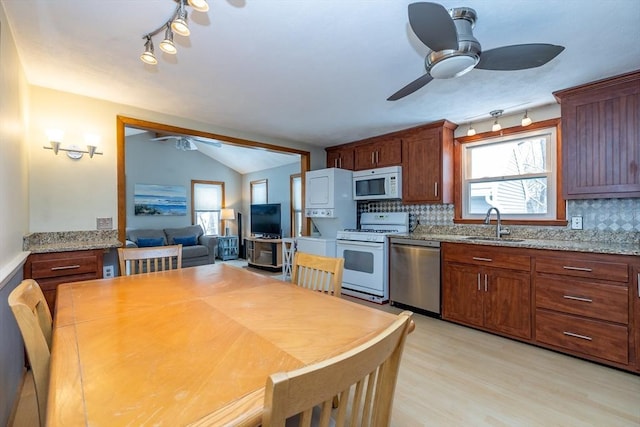 kitchen with light stone counters, white appliances, and decorative backsplash