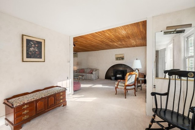 living area with wood ceiling and light colored carpet