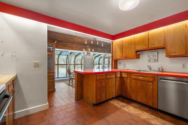 kitchen with a peninsula, a sink, light countertops, brown cabinets, and dishwasher