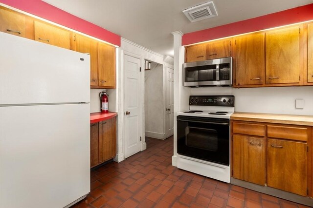 kitchen with visible vents, electric stove, light countertops, freestanding refrigerator, and stainless steel microwave