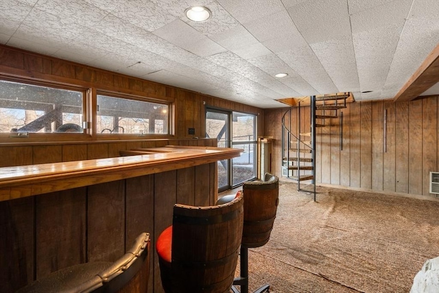 bar with a dry bar, wood walls, stairs, and carpet flooring