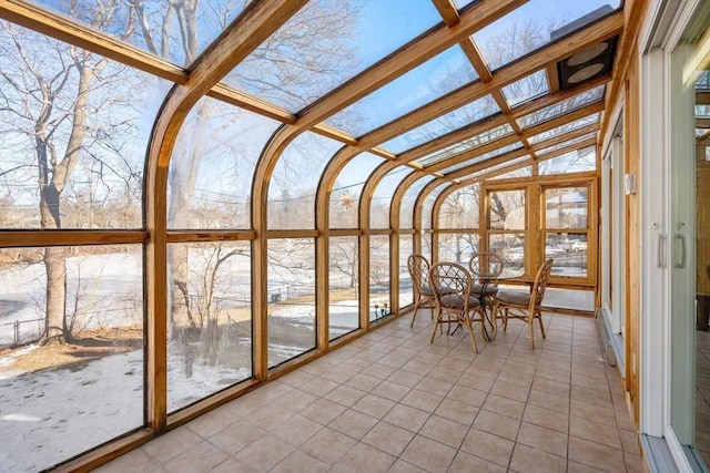 unfurnished sunroom with lofted ceiling with beams