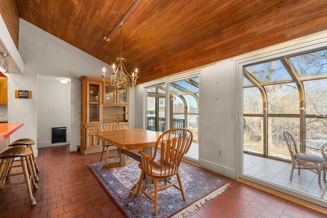 dining area featuring brick floor, high vaulted ceiling, track lighting, a chandelier, and wooden ceiling