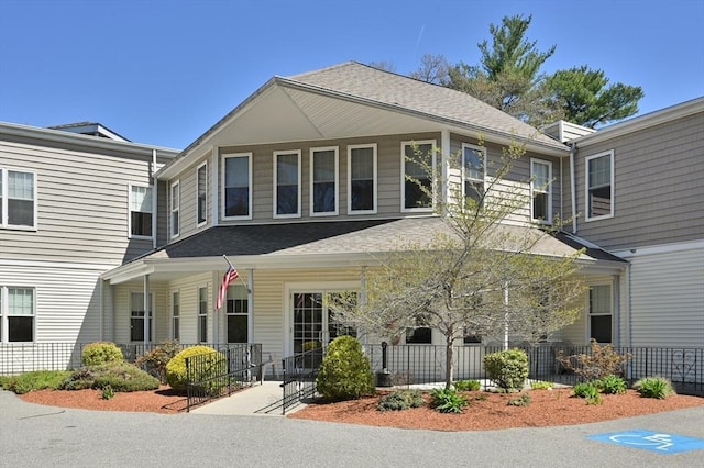 view of front of house with a shingled roof and a porch
