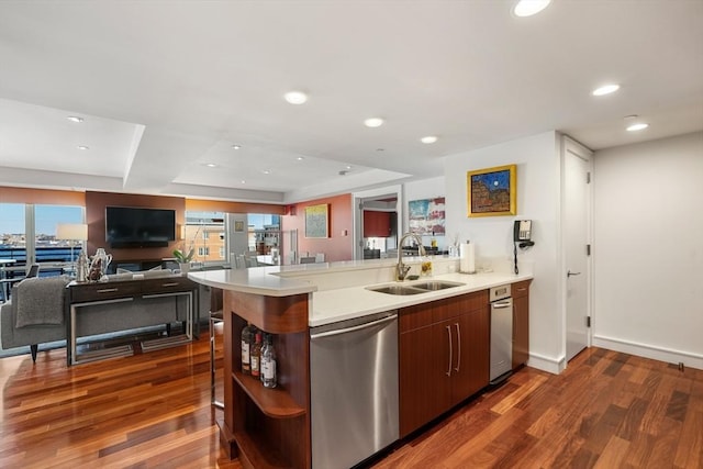 kitchen featuring kitchen peninsula, dishwasher, sink, and dark hardwood / wood-style flooring