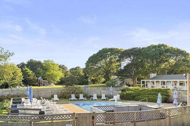 view of pool with a playground and a patio