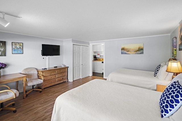 bedroom with track lighting, wood-type flooring, a closet, and ornamental molding