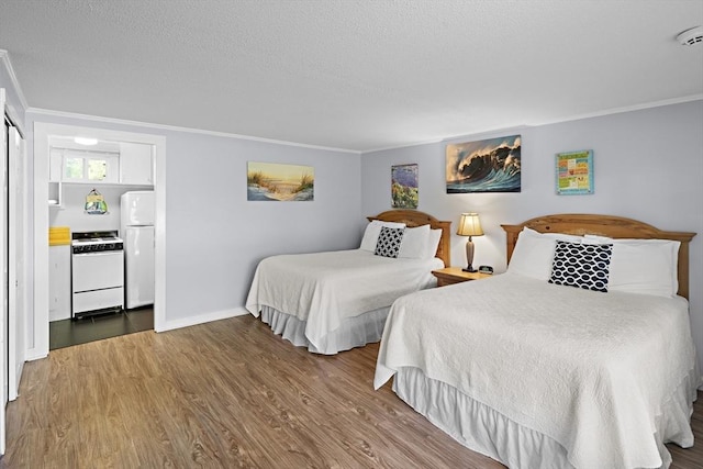 bedroom featuring wood-type flooring, white fridge, and crown molding