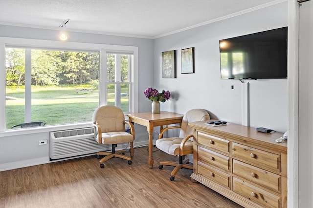 living area with track lighting, a wall unit AC, crown molding, and hardwood / wood-style floors