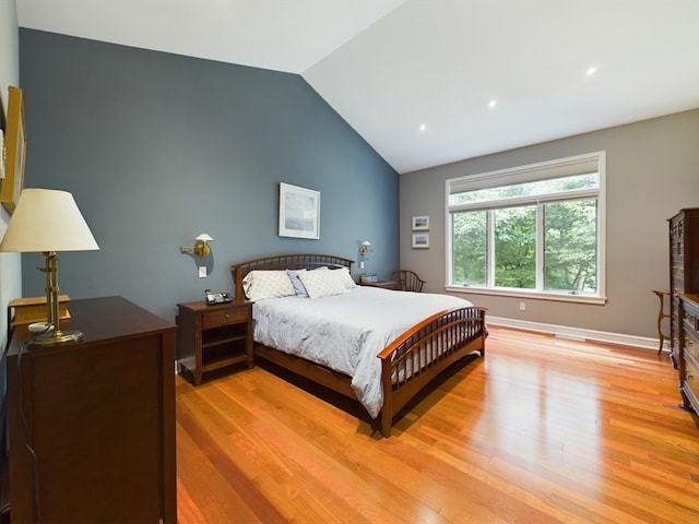 bedroom with vaulted ceiling and light hardwood / wood-style floors