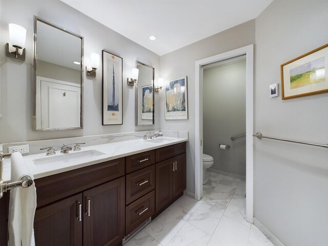 bathroom featuring toilet, tile patterned flooring, and dual bowl vanity