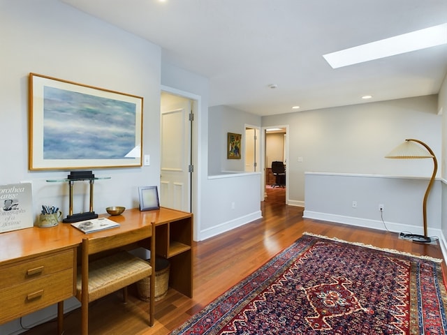 office space with a skylight and hardwood / wood-style floors