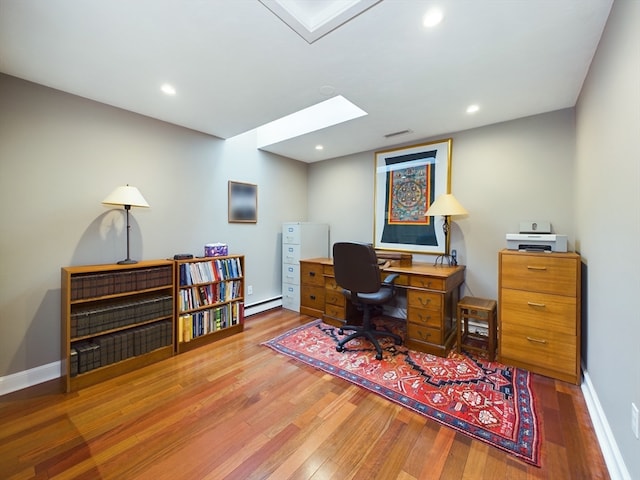 office area with a baseboard heating unit and hardwood / wood-style flooring