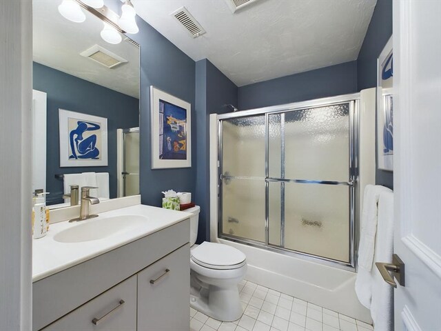 full bathroom with vanity, tile patterned flooring, enclosed tub / shower combo, and toilet