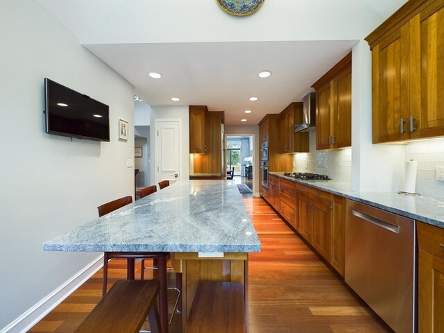 kitchen with wall chimney range hood, dark hardwood / wood-style floors, tasteful backsplash, and stainless steel appliances