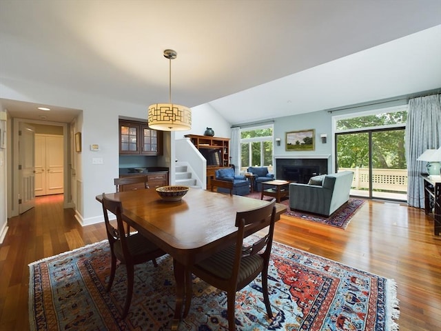 dining space with dark hardwood / wood-style flooring and vaulted ceiling