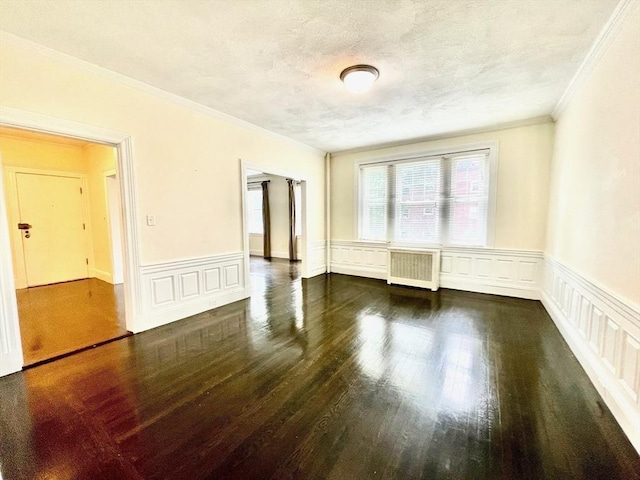 132 Sewall Ave Unit B, Brookline, MA 02446 - spare room featuring radiator heating unit, ornamental molding, wood finished floors, wainscoting, and a decorative wall