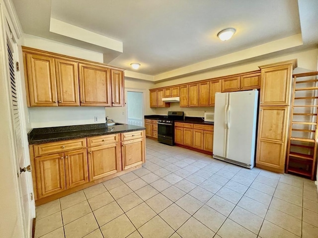 132 Sewall Ave Unit B, Brookline, MA 02446 - kitchen featuring white appliances, under cabinet range hood, light tile patterned floors, brown cabinetry, and dark stone countertops